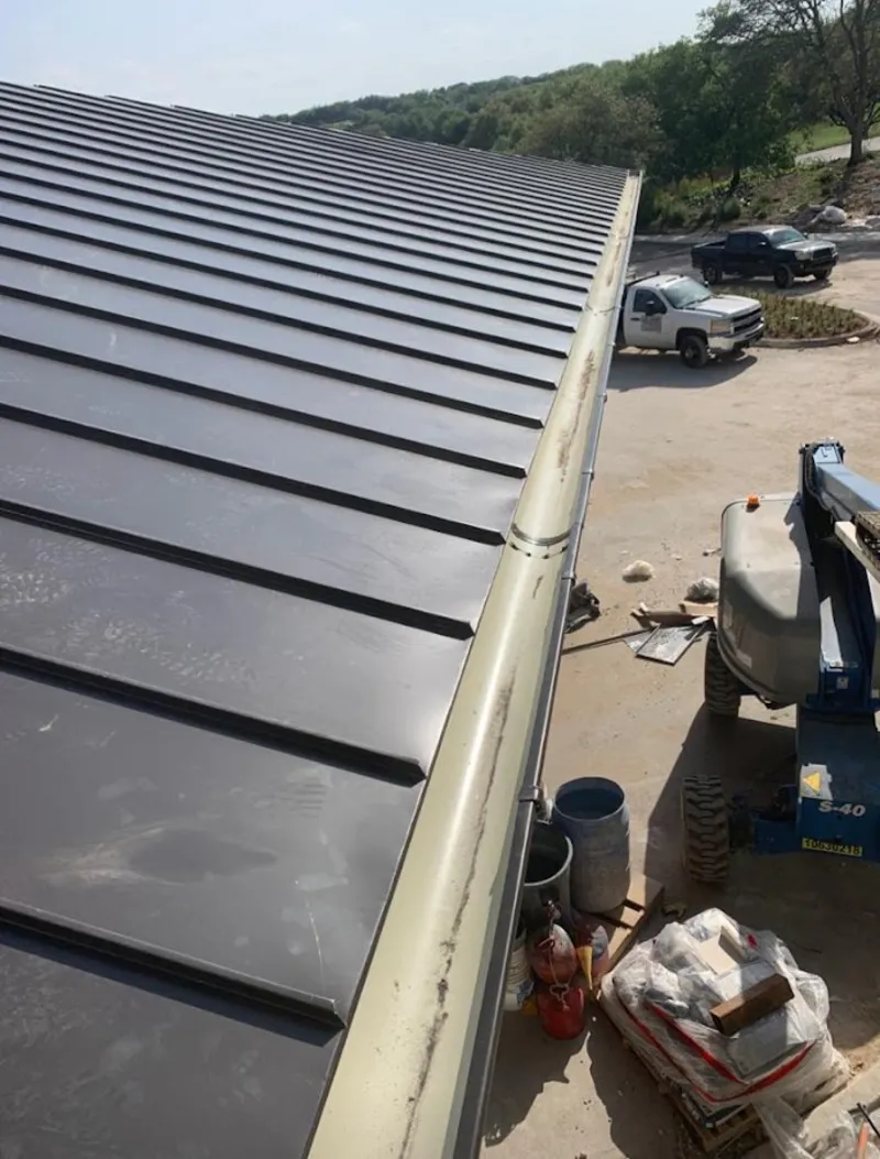 Standing seam panel and gutter detail on a metal roofing jobsite in Highland City